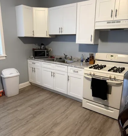 a kitchen with a stove and white cabinets