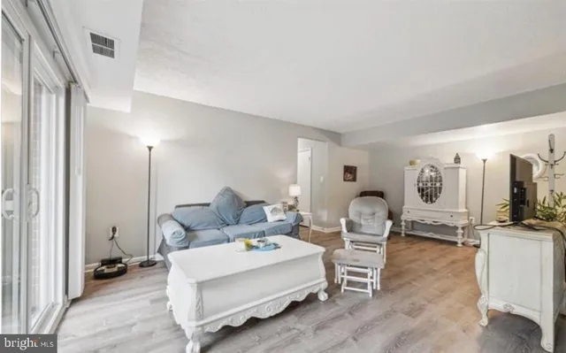 a living room with furniture a large window and gym equipment