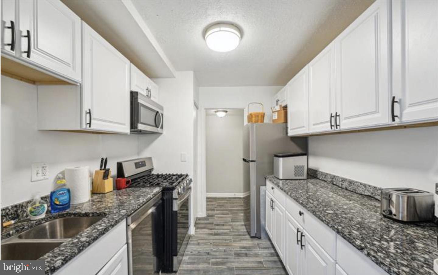 3841 St Barnabas Road, Unit T1 Suitland, MD 20746 - Photo 8 of 14 a kitchen with stainless steel appliances granite countertop a sink stove and cabinets