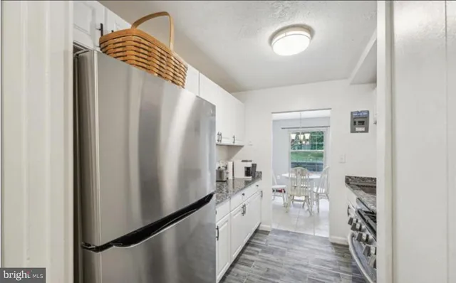 a kitchen with stainless steel appliances a refrigerator and a wooden floor