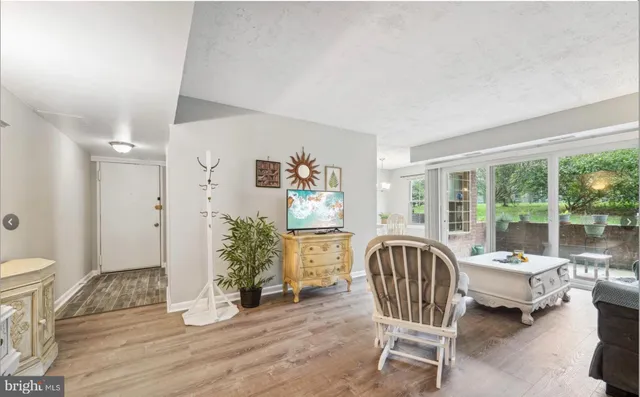 a living room with furniture floor to ceiling window and wooden floor