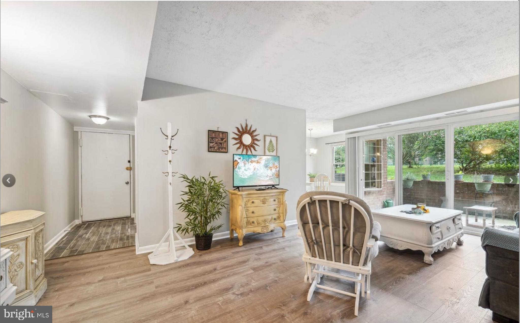 3841 St Barnabas Road, Unit T1 Suitland, MD 20746 - Photo 10 of 14 a living room with furniture floor to ceiling window and wooden floor
