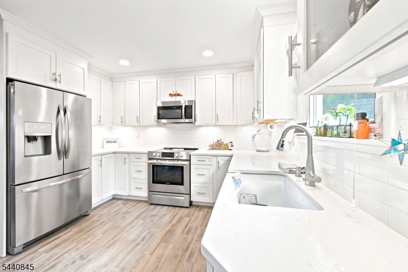 36 Forest Road Andover, NJ 07821 - Photo 26 of 50 a kitchen with white cabinets and stainless steel appliances