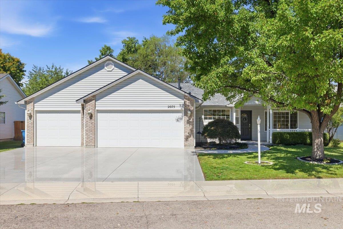 2075 North Springland Place Boise, ID 83713 - Photo 3 of 49 Single-story residence featuring light gray siding with brick accents, a two-car garage, and a manicured front lawn