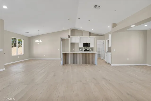 a view of an empty room with a window and a ceiling fan
