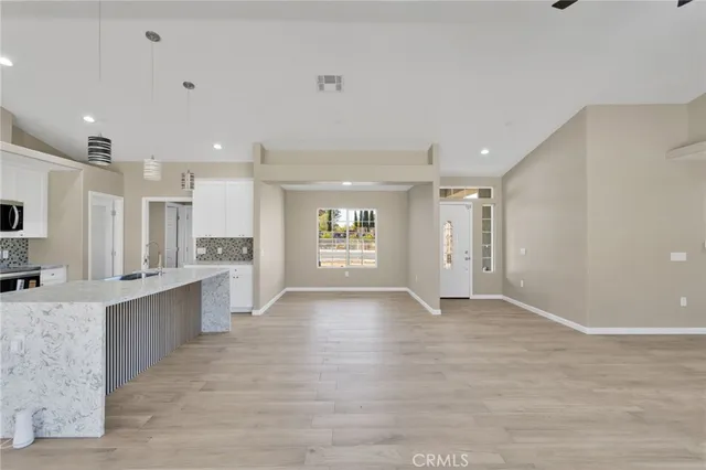 a large kitchen with stainless steel appliances granite countertop a lot of counter space and wooden floor