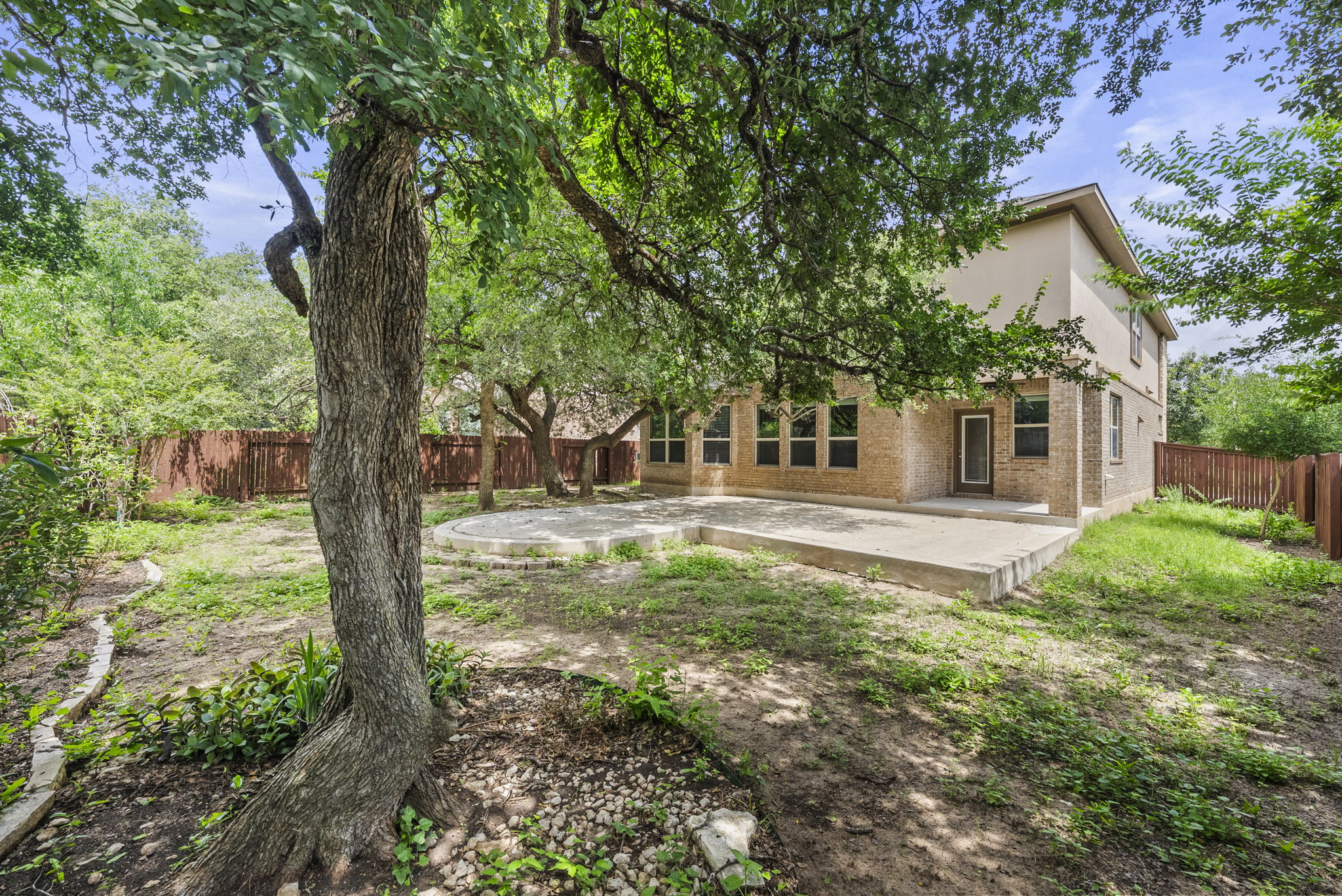 4401 Trinity Woods Street Leander, TX 78641 - Photo 33 of 37 A spacious yard with mature trees and a fenced perimeter offers a large patio for outdoor enjoyment.