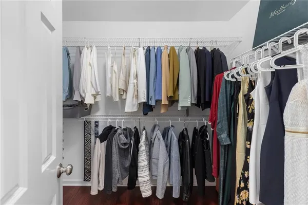 a view of walk in closet with clothes and shoes