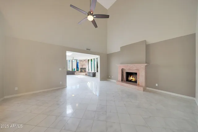 an empty room with windows and fireplace