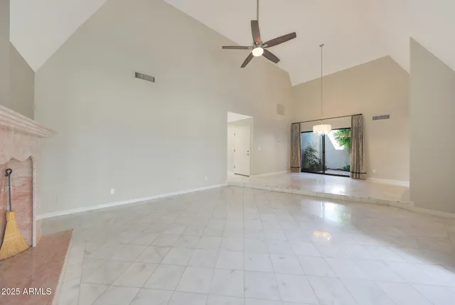 an empty room with fan and windows