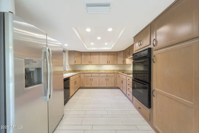 a large kitchen with a large counter top stainless steel appliances and cabinets