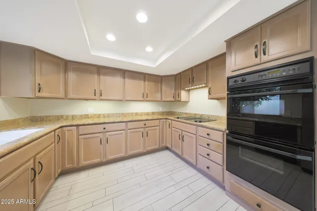 a kitchen with granite countertop cabinets stainless steel appliances and a sink