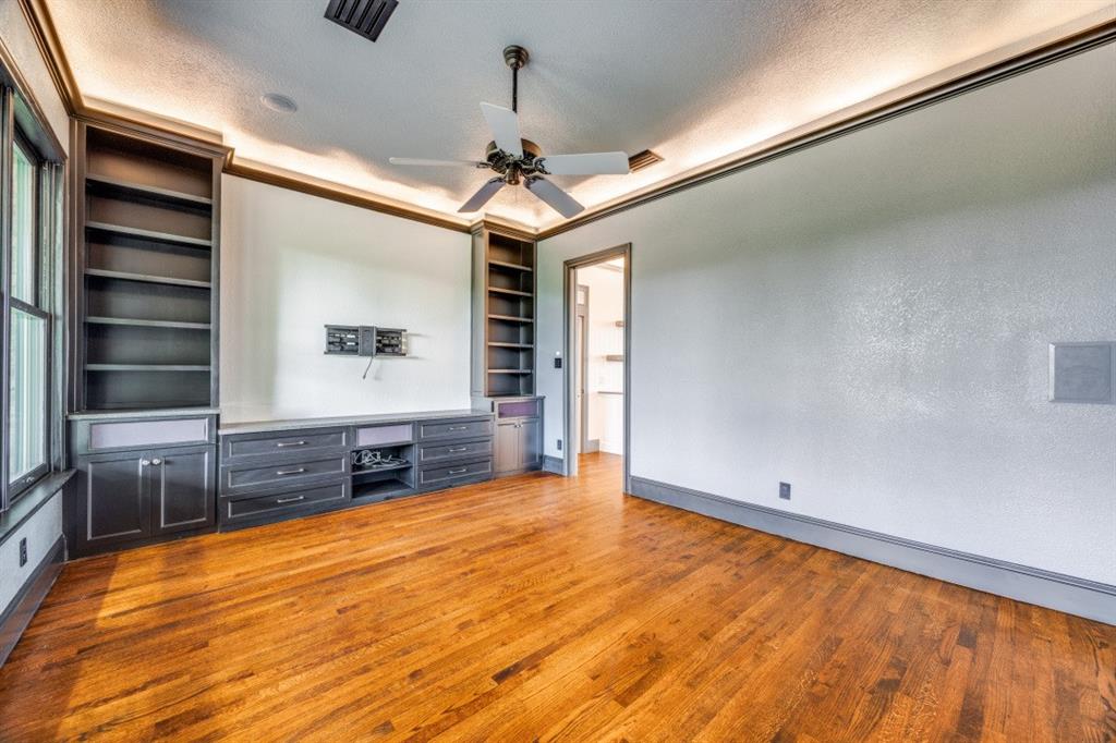 3244 Joe Davis Road Whitewright, TX 75491 - Photo 11 of 28 Unfurnished living room featuring wood finished floors, a ceiling fan, and built in shelves