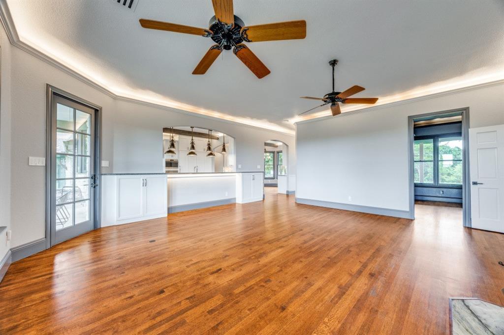 3244 Joe Davis Road Whitewright, TX 75491 - Photo 10 of 28 Unfurnished living room featuring a ceiling fan, crown molding, light wood-style floors, and arched walkways