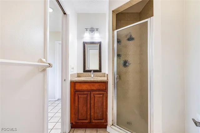 a bathroom with a granite countertop shower a sink and a mirror