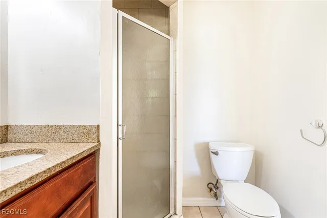 a bathroom with a granite countertop toilet and a sink