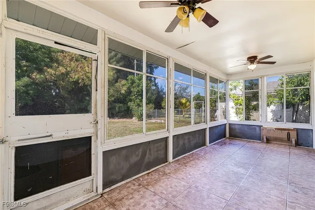 a view of an empty room with a fireplace and windows