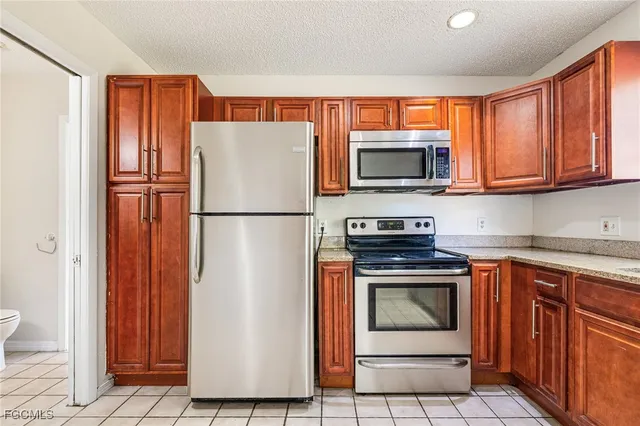 a kitchen with granite countertop a refrigerator stove and microwave