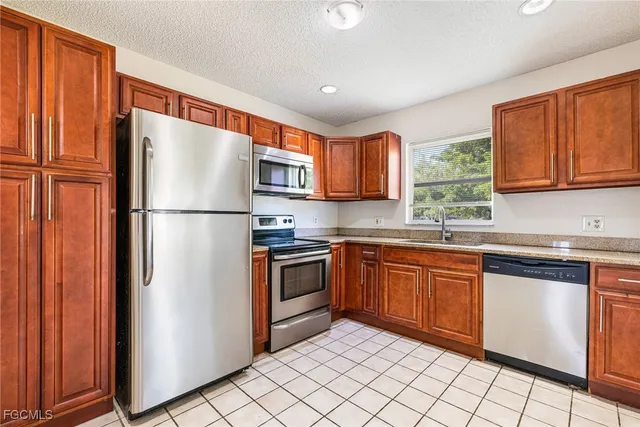 a kitchen with stainless steel appliances granite countertop a refrigerator sink and cabinets
