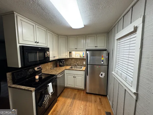 a kitchen with a refrigerator sink and cabinets