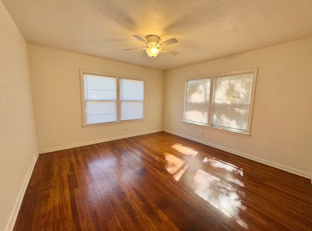 110 East 8th Street Elgin, TX 78621 - Photo 14 of 17 a view of an empty room with wooden floor and a window