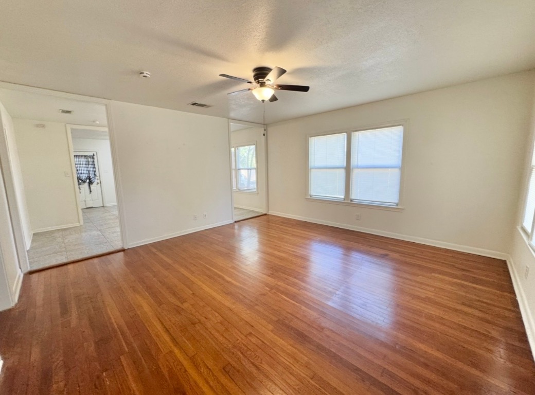 110 East 8th Street Elgin, TX 78621 - Photo 4 of 17 wooden floor in an empty room with a window
