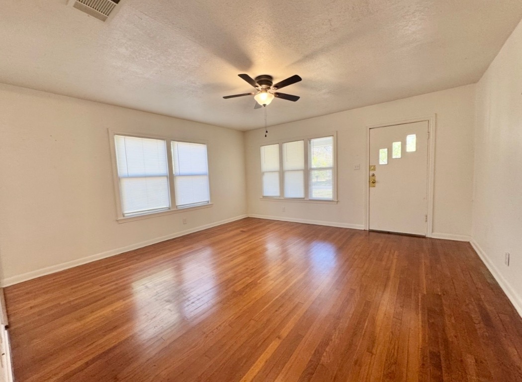 110 East 8th Street Elgin, TX 78621 - Photo 5 of 17 a view of an empty room with wooden floor and a window