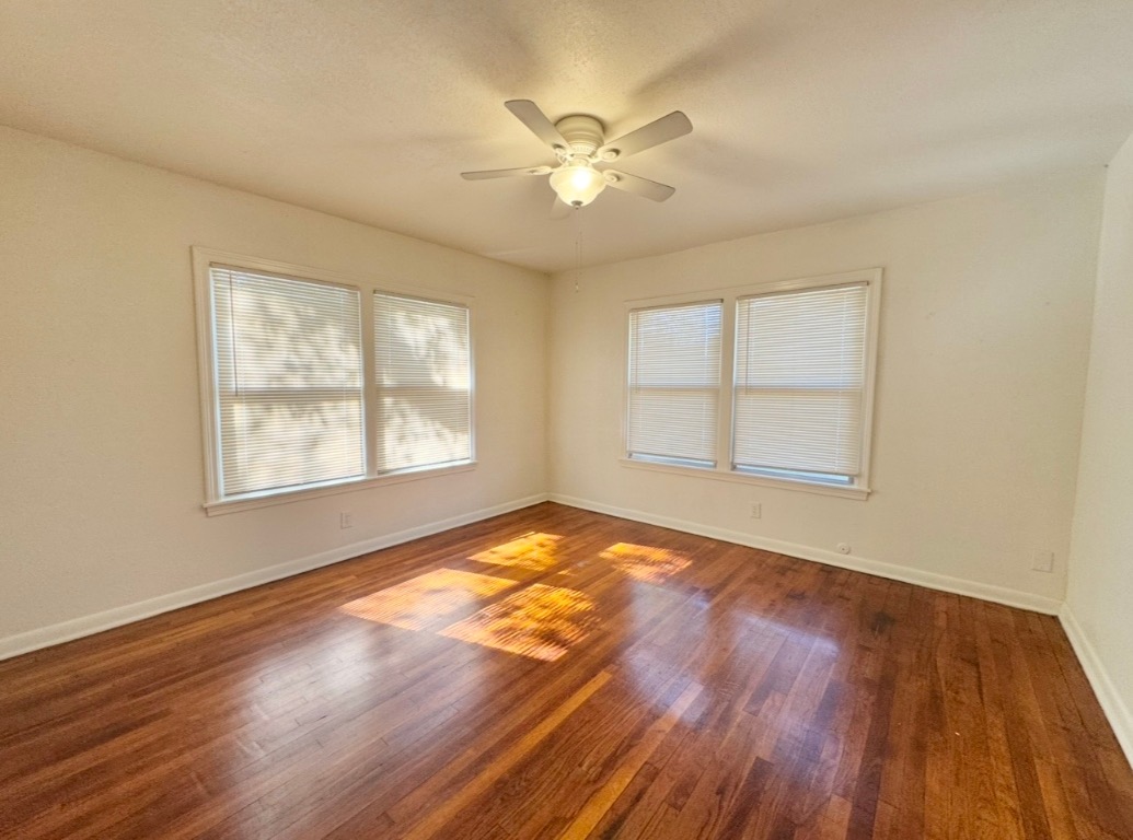 110 East 8th Street Elgin, TX 78621 - Photo 10 of 17 a view of an empty room with wooden floor and a window