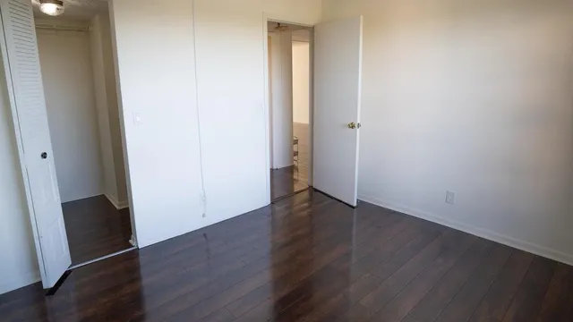 an empty room with wooden floor and closet