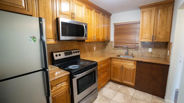 a kitchen with stainless steel appliances granite countertop a stove a sink and a microwave