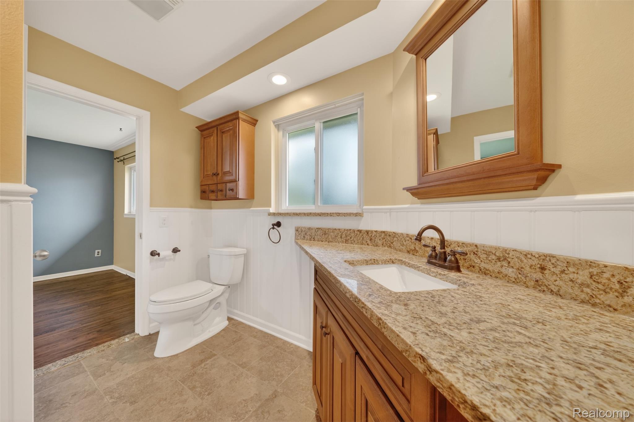 12014 Common Road Warren, MI 48093 - Photo 25 of 30 Primary bathroom with wainscoting, vanity, and recessed lighting
