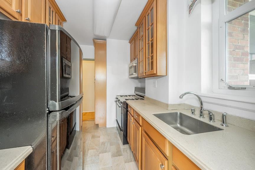 5355 Henry Hudson Parkway West, Unit 5C Bronx, NY 10471 - Photo 7 of 13 a kitchen with stainless steel appliances granite countertop a refrigerator and a sink