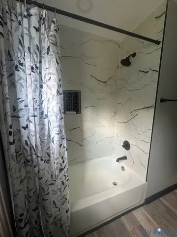 a bathroom with a bathtub and shower