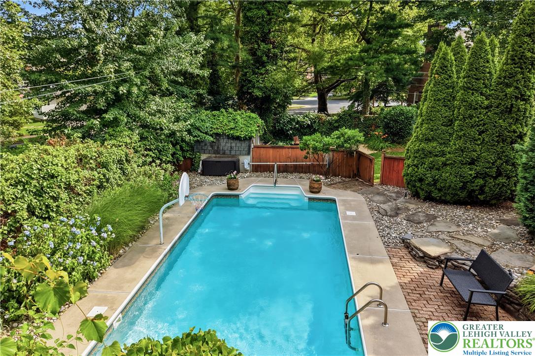 2014 Linden Street Bethlehem, PA 18017 - Photo 56 of 85 A tranquil backyard oasis features a glistening inground pool surrounded by lush foliage and a stone path.