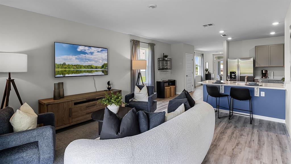 3316 White Indigo Road Winter Haven, FL 33884 - Photo 14 of 27 a living room with furniture a flat screen tv and kitchen view
