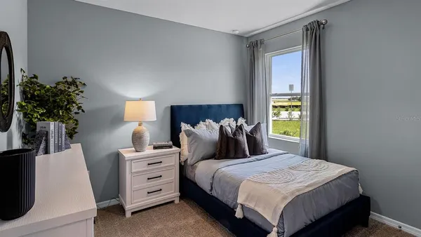 a bedroom with a bed and a potted plant