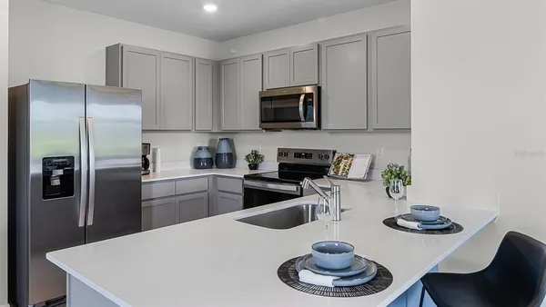 a kitchen with stainless steel appliances granite countertop a sink a stove and refrigerator