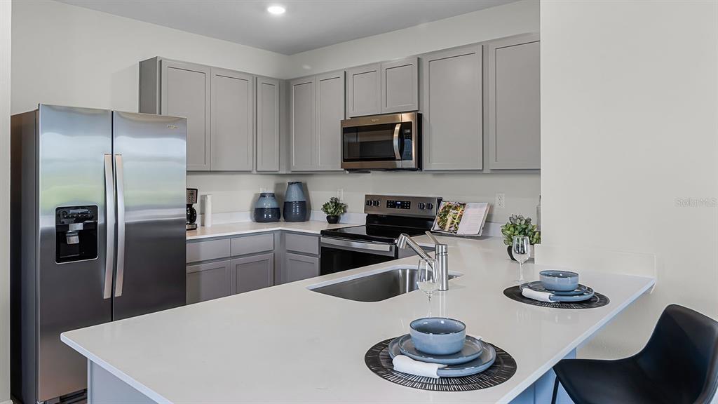 3316 White Indigo Road Winter Haven, FL 33884 - Photo 6 of 27 a kitchen with stainless steel appliances granite countertop a sink a stove and refrigerator