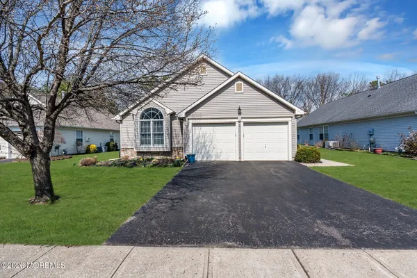 a view of a house with a big yard and large tree