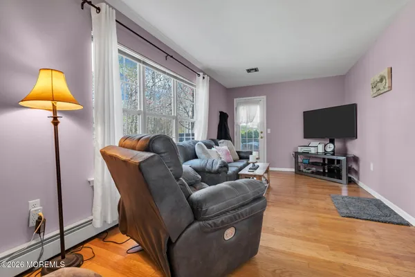 a living room with furniture a lamp and a flat screen tv