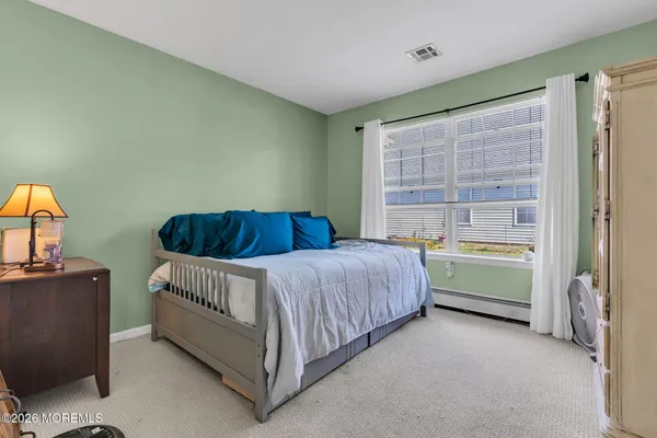 a spacious bedroom with a bed and a window