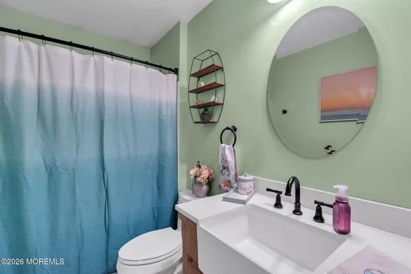 a bathroom with a sink vanity mirror and toilet