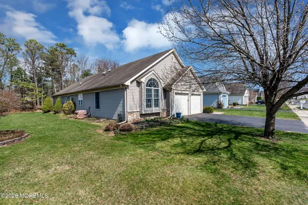 a view of an house with backyard and a tree