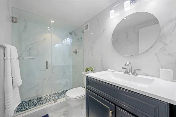 a bathroom with a sink a toilet and shower