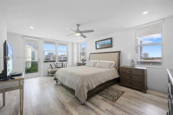 a bedroom with a large bed a flat tv screen and furniture