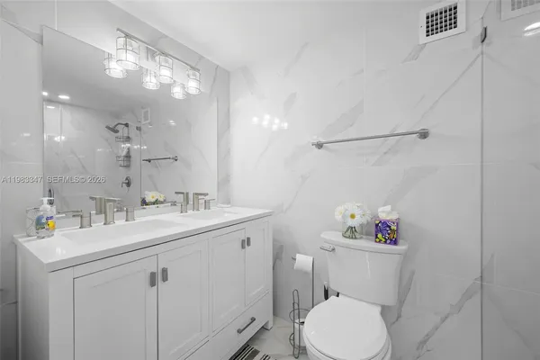 a bathroom with a sink mirror vanity and toilet