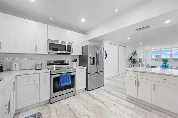 a kitchen with stainless steel appliances granite countertop a stove a sink and a refrigerator