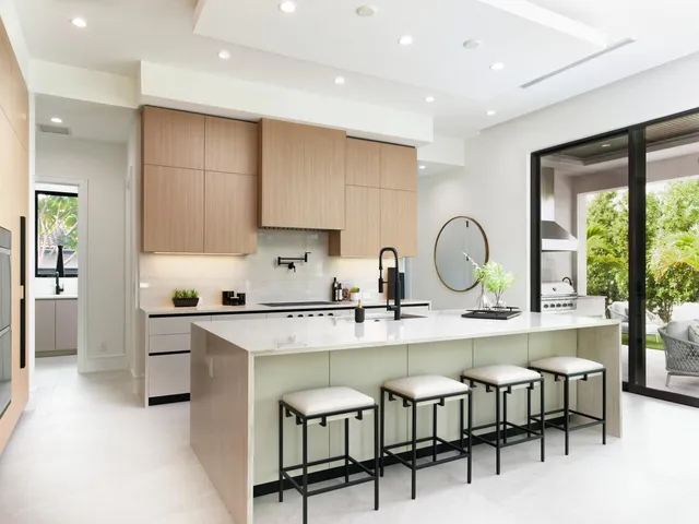 a kitchen with stainless steel appliances granite countertop a table chairs sink and cabinets