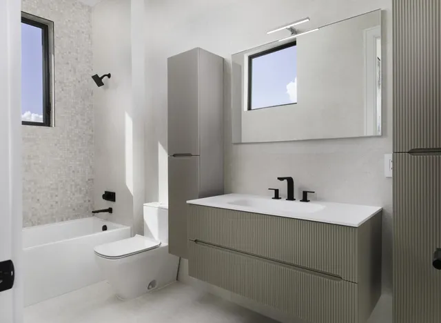 a bathroom with a sink a toilet and shower