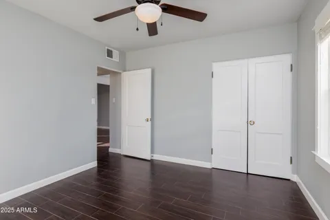 an empty room with window and a ceiling fan